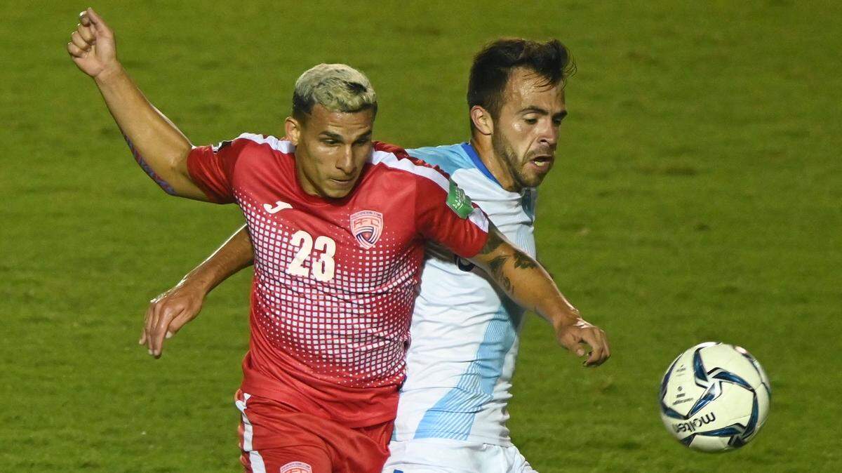 El jugador de Cuba Luis Paradela (izq.) lucha por el balón con Rodrigo Saravia, de Guatemala, en el partido de la eliminatoria mundialista de la CONCACAF, celebrado el 24 de marzo de 2021 en Ciudad de Guatemala.