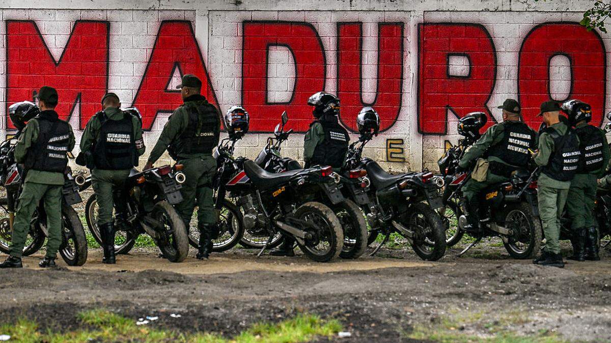 Miembros de la Guardia Nacional están asignados a una calle frente a un mural del exgobernante Nicolás Maduro, el sábado 10 de enero de 2026, en Caracas, Venezuela.