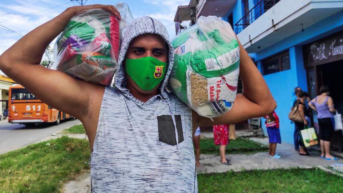 Un cubano porta un módulo de alimentos en el municipio de Arroyo Naranjo en La Habana, el 11 de agosto de 2021. YAMIL LAGE / AFP/ Getty Images
