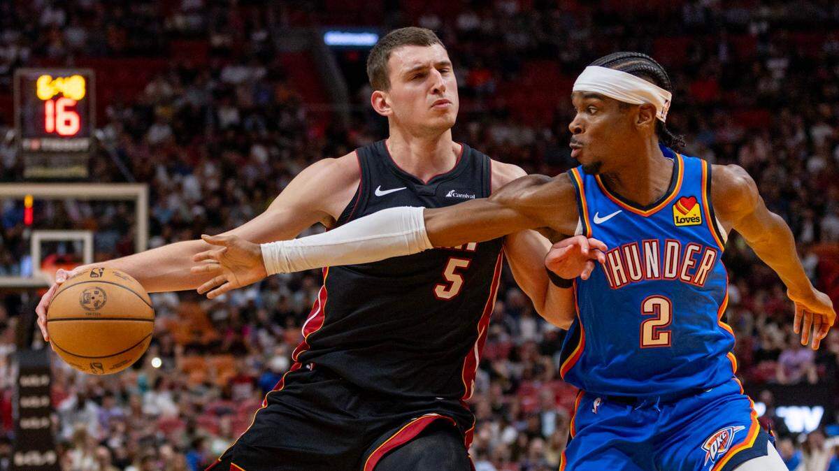 El jugador del Heat Nikola Jovic (izq.) conduce la pelota ante la marca de Shai Gilgeous-Alexander, del Thunder de Oklahoma, en el partido celebrado el 10 de enero de 2024 en Miami.
