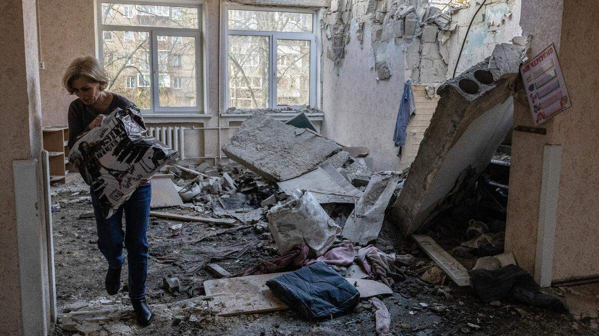 Una maestra carga libros y juguetes de un jardín de infancia destruido por un dron ruso, en Kiev, Ucrania, el sábado 25 de noviembre de 2023.