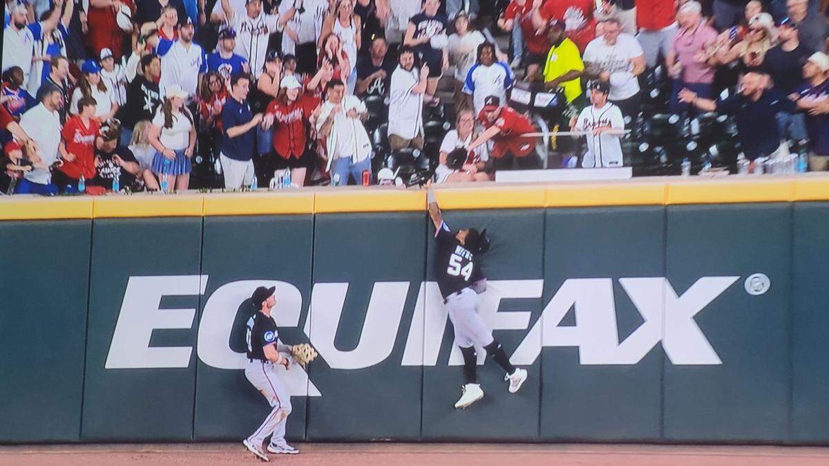 Momento en que Dane Myers trata de captura el batazo de Matt Olson que finalmente fue declarado cuadrangular para los Bravos de Atlanta.