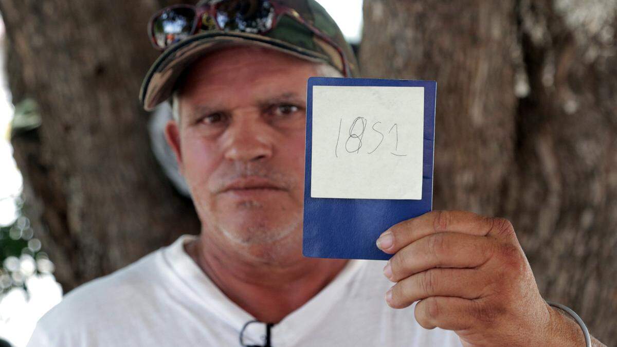 Jorge Luis Fleites, a Cuban migrant currently waiting in Matamoros, Mexico, for his chance to ask for asylum in the United States, holds up his number in line. He has been waiting for two months since he arrived at the border and was hoping to be able to get in in the next few days after this photo was taken.