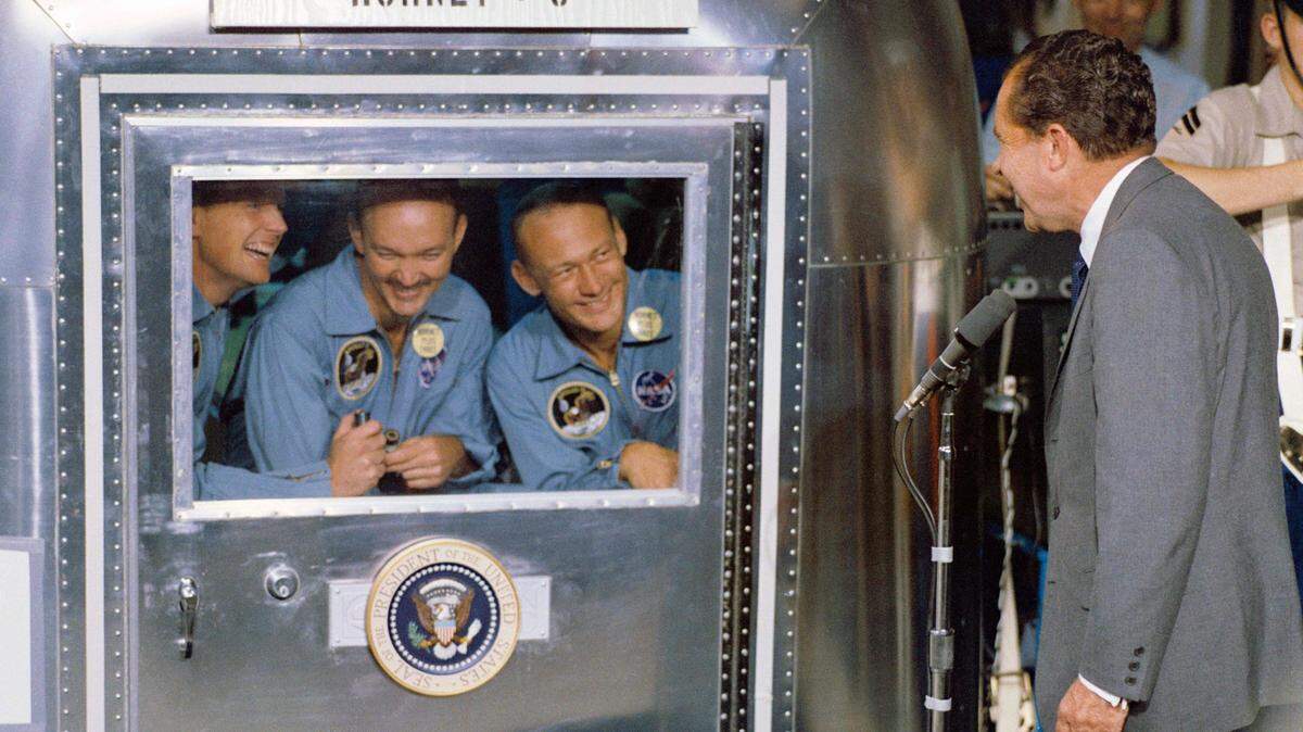 This July 24, 1969, El presidente Richard Nixon (d) saluda a los astronautas del Apollo 11 el 24 de julio de 1969.