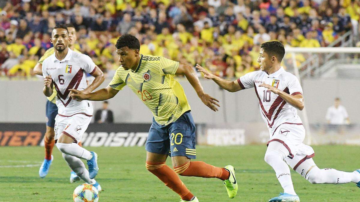 El jugador de Colombia Roger Hernández (centro) disputa el balón con el venezolano Jefferson Sabatino (der.) en el partido amistoso celebrado el 10 de septiembre de 2019 en el estadio Raymond James, en Tampa.