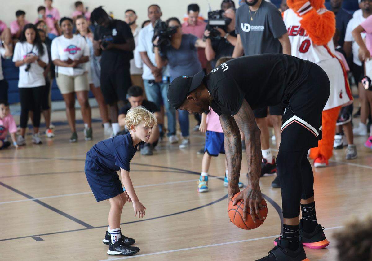 El jugador del Heat Udonis Haslem interactúa con un pequeño en el último día de su campamento de baloncesto para niños, que se llevó a cabo en su alma mater, Miami Senior High School, el 21 de agosto de 2022.