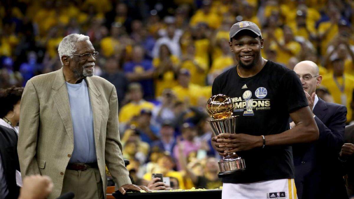 Kevin Durant recibe el trofeo de Jugador Más Valioso en presencia del legendario exjugador Bill Russell, durante la ceremonia de premiación de los Warriors como campeones de la NBA. Golden State derrotó 129-120 a los Cavaliers, el 12 de junio del 2017.