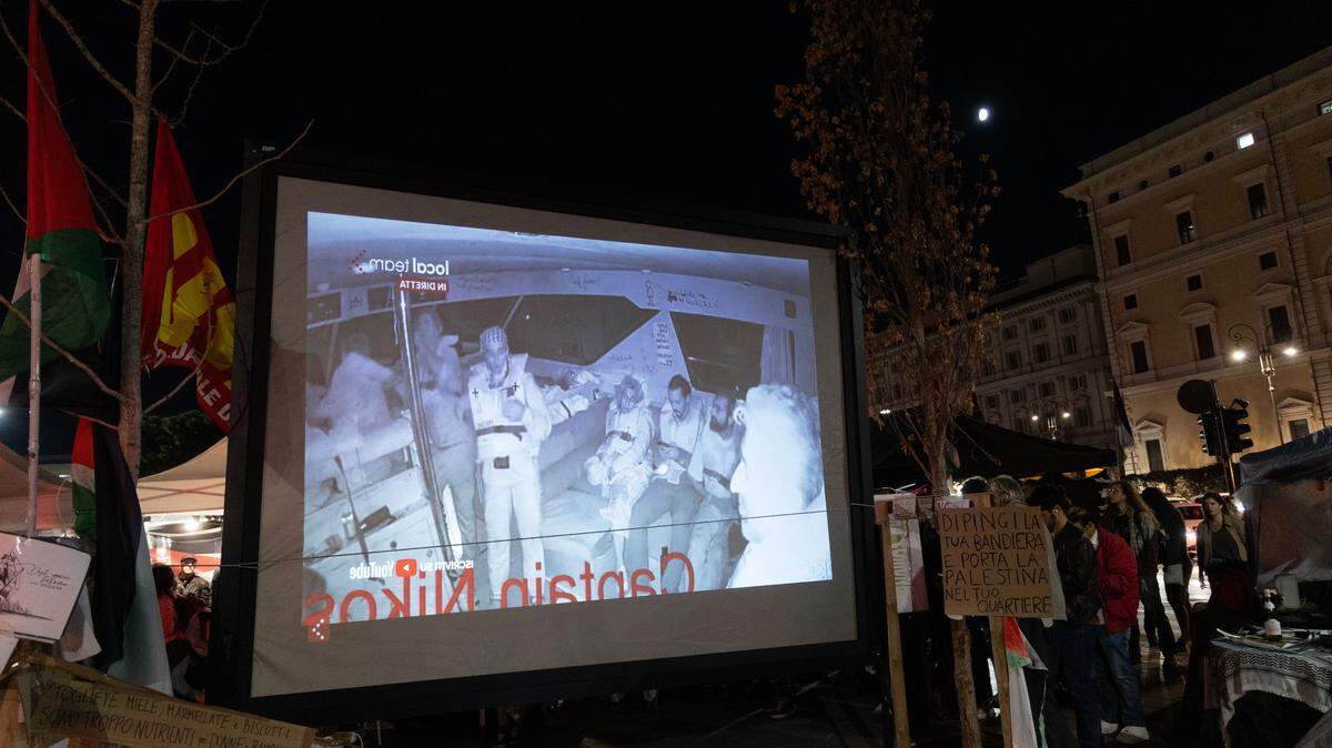 Decenas de personas siguen en vivo la cobertura de la intercepción de la Flotilla Global Sumud por botes israelíes, el miércoles 1 de octubre de 2025, en Roma.