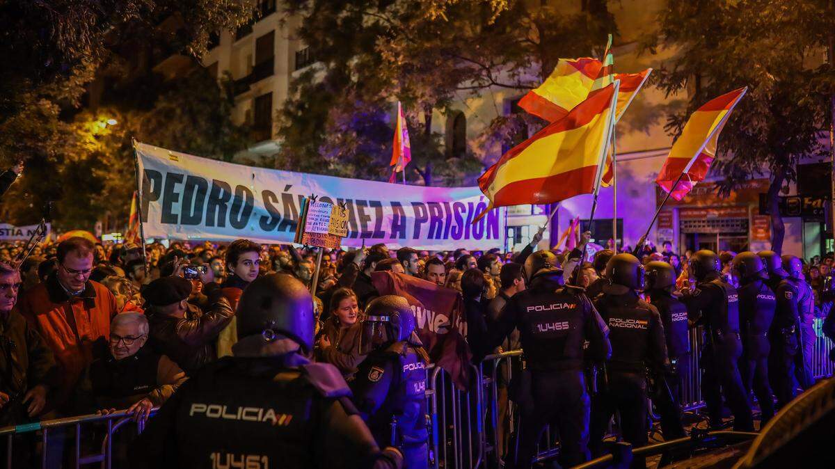 Decenas de personas ondean banderas de España y pancartas críticas del presidente del gobierno Pedro Sánchez, el viernes 3 de noviembre de 2023, en Madrid.