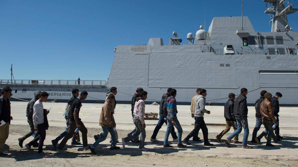 Cientos de migrantes desembarcan de un buque italiano, en un puerto de Sicilia, luego de ser rescatados en el Mediterráneo.