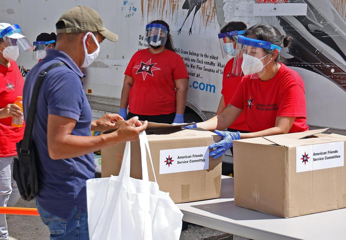 Bailyn Lopez, right, distributes food as 100 tests were administered and 100 boxes of food were distributed in order to engage the migrant community in COVID-19 testing and dispelling COVID-19 rumors on Sunday, August 30, 2020, in Miami-Dade’s agricultural neighborhood in Redland. The Florida Health Department, along with 15 volunteers with the American Friends Service Committee, distributed a box of food for each test taken by workers and their families.
