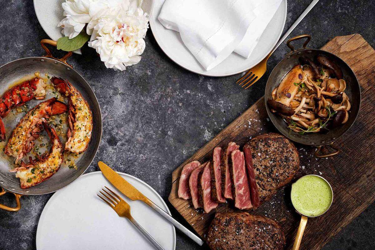 Wild Fork ofrece un paquete llamado “Classic Surf & Turf de Wild Fork”: colas de langosta, filet mignon envuelto en tocino Berkshire ahumado de Applewood, acompañado de brócoli y queso gratinados.