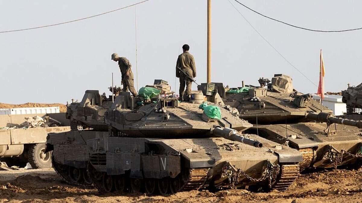 SOUTHERN ISRAEL, ISRAEL - NOVEMBER 18: Israeli soldiers stand on a tank near the border with the Gaza Strip on November 18, 2025 in Southern Israel, Israel. Yesterday, the United Nations Security Council approved a temporary international stabilization force (ISF) in Gaza, as part of US President Donald Trump's 20-point plan to bring peace to the enclave. Under the resolution, the ISF will be responsible for "securing Gaza's borders, protecting civilians, facilitating humanitarian assistance, supporting the training and deployment of a reconstituted Palestinian police force, and overseeing the permanent de-commissioning of weapons held by Hamas and other armed groups in the enclave." The draft also provides guidelines for a pathway to Palestinian statehood. (Photo by Amir Levy/Getty Images)