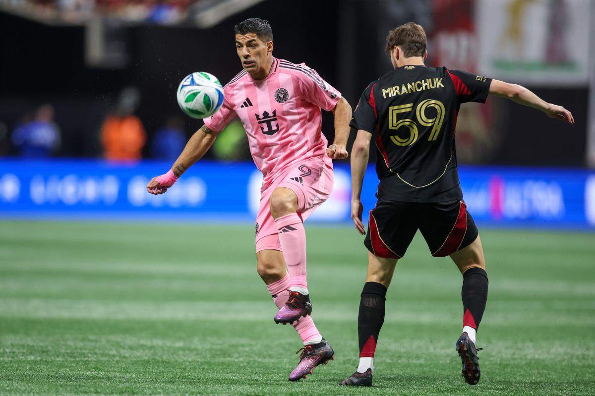 El delantero del Inter Miami Luis Suárez (izq.) lucha por la pelota con Aleksey Miranchuk, del Atlanta United, en el partido de la MLS efectuado el 16 de marzo de 2025 en el Mercedes-Benz Stadium en Atlanta.