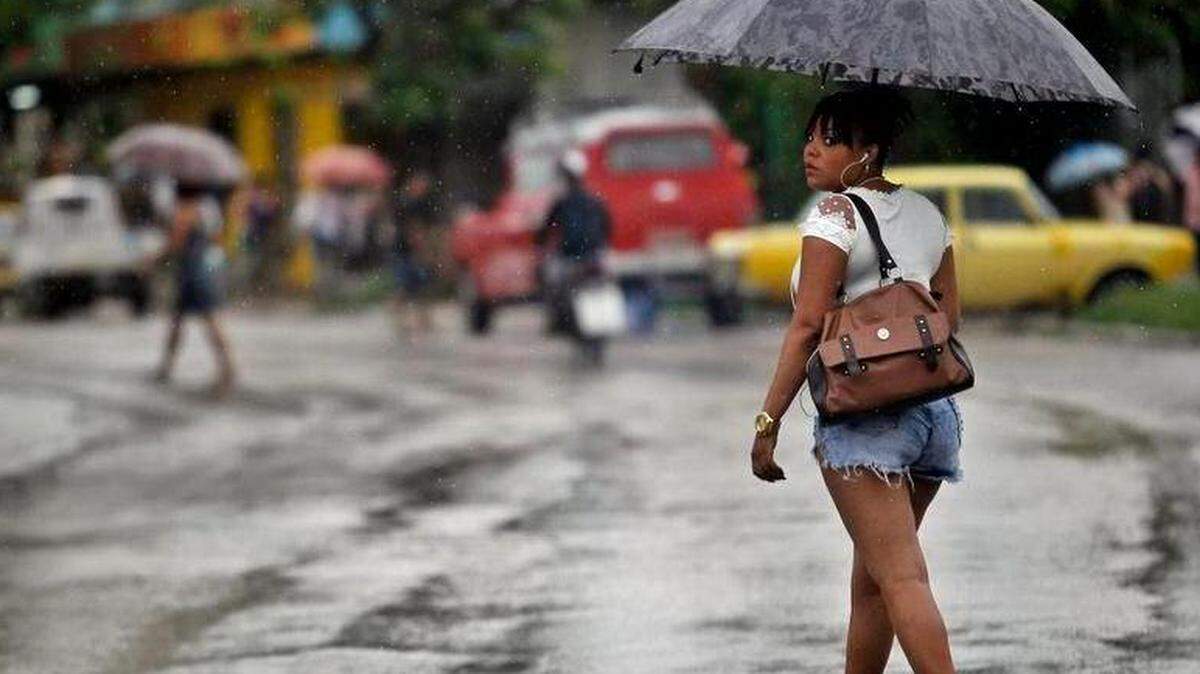 Una mujer cruza una calle en medio de la lluvia el martes 29 de mayo del 2018, en La Habana (Cuba).