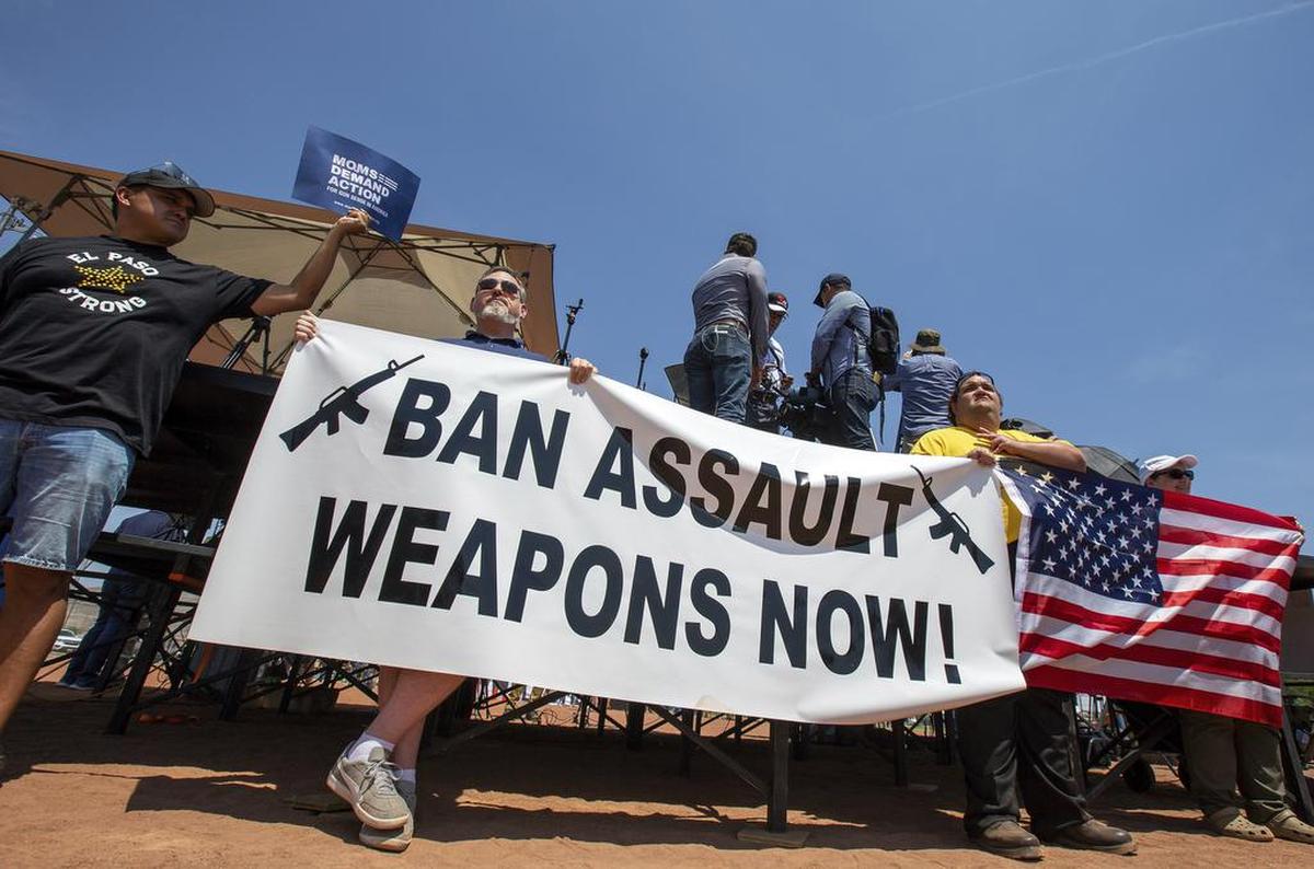 Protesters hold a banner during President Donald Trump’s Aug. 7, 2019, visit to El Paso, Texas, after the Aug. 3 mass shooting in the border city.