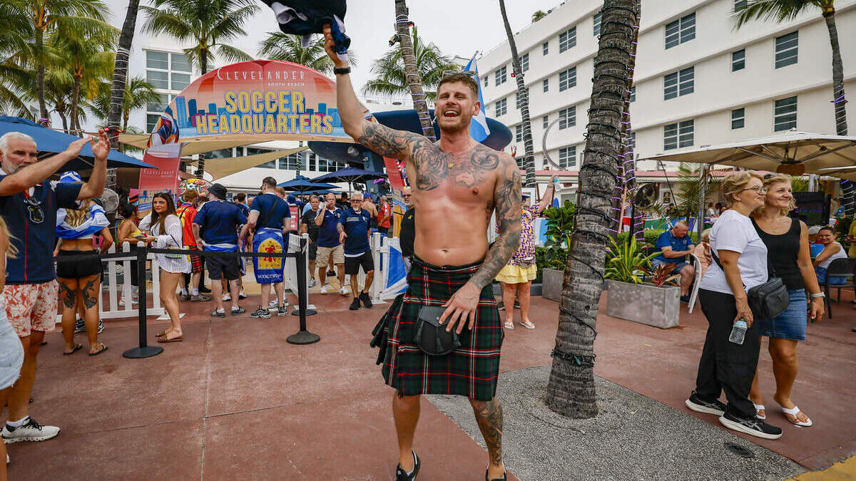 Kyle Tait, aficionado de la selección de fútbol de Escocia, salta frente al hotel The Clevelander mientras la “Tartan Army” desfila por Ocean Drive en Miami Beach, el martes 23 de junio de 2026.