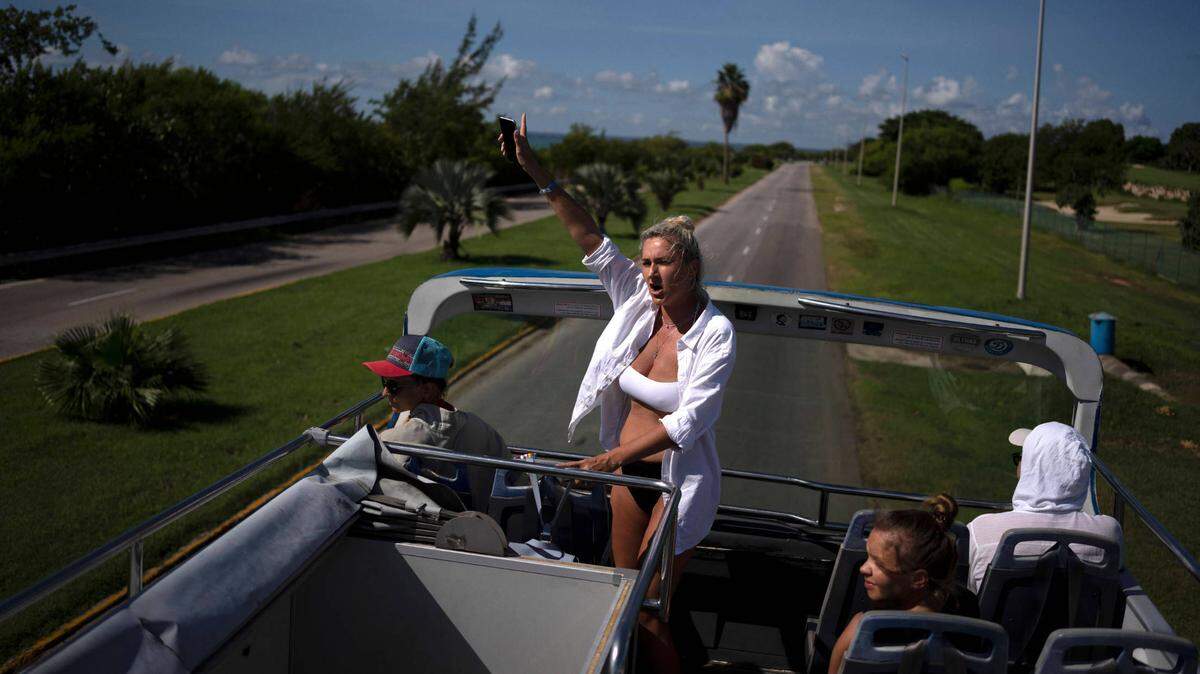 Turistas rusos saludan desde un bus durante un recorrido por la ciudad de Varadero, Cuba, el 29 de septiembre de 2021.