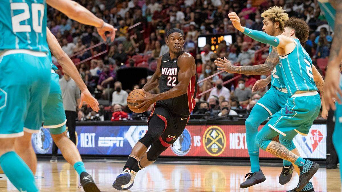 El delantero del Miami Heat Jimmy Butler (22) conduce hacia la canasta, mientras varios jugadores Charlotte Hornets defienden en el FTX Arena de Miami, el viernes 29 de octubre de 2021.