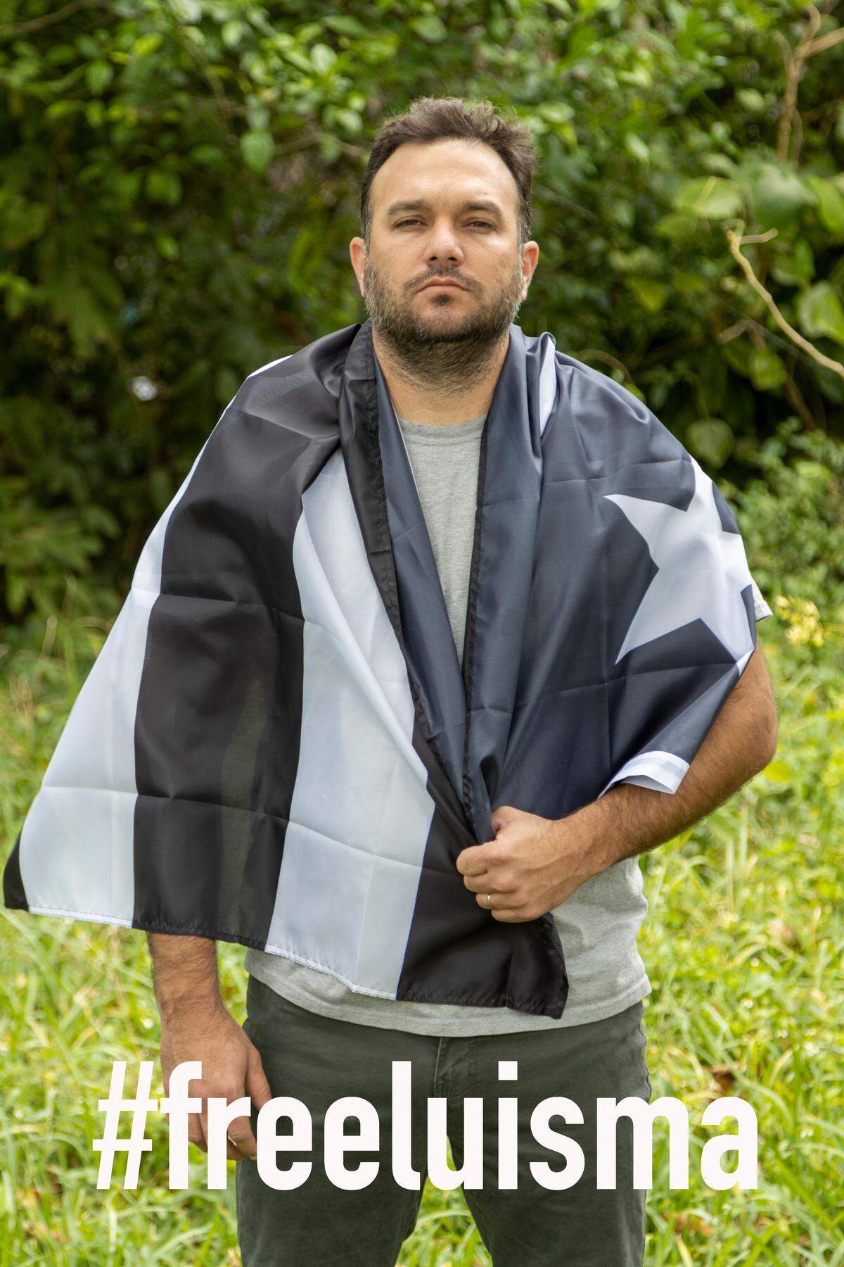 El cineasta Eliécer Jiménez Almeida lleva una bandera cubana con las franjas en negro para expresar el luto por el encarcelamiento de Luis Manuel Otero Alcántara en la prisión de Valle Grande. Jiménez Almeida es uno de los firmantes de la carta en la que artistas e intelectuales cubanos piden su liberación.