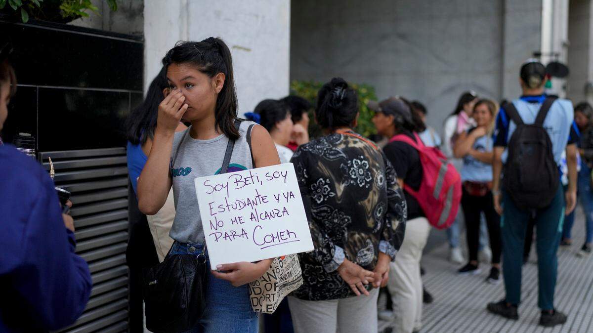 Una mujer sostiene un cartel mientras hace fila afuera de la oficina de la ministra de Capital Humano, Sandra Pettovello. La funcionaria había dicho que asistiría personalmente a las personas con hambre en Buenos Aires, Argentina, el lunes 5 de febrero de 2024.