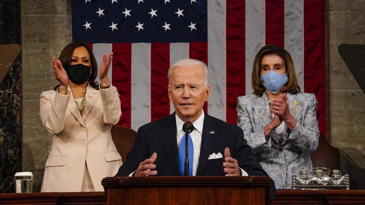 El presidente Joe Biden se dirige a una sesión conjunta del Congreso con la vicepresidenta Kamala Harris (izq.) y la presidenta de la Cámara de Representantes Nancy Pelosi en el estrado detrás, el 28 de abril de 2021 en Washington, DC.