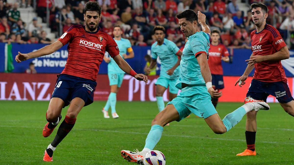 El delantero de Barcelona Robert Lewandowski patea el balón ante la defensa de Alejandro Catena, de Osasuna, en el partido de la liga española celebrado el 3 de septiembre de 2023 en Pamplona.
