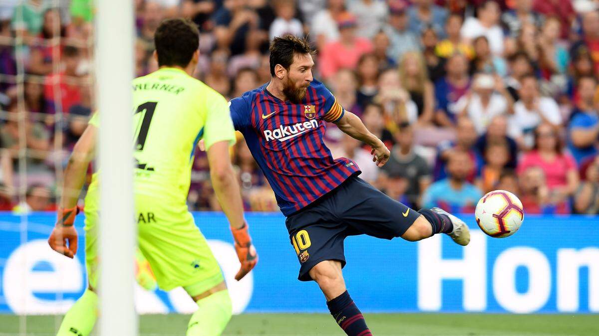 Lionel Messi dispara a puerta por Barcelona ante el portero del Huesca Axel Werner, en partido de la liga española celebrado el 2 de septiembre de 2018.