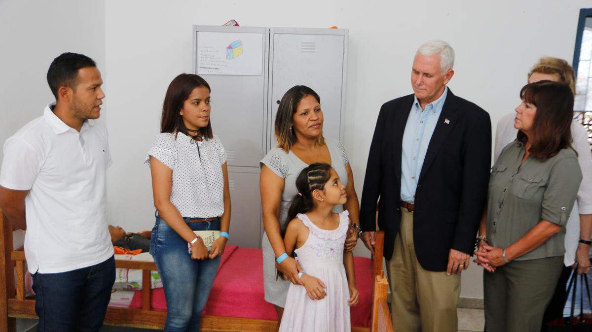 El vicepresidente de EEUU, Mike Pence (2 der.) y su esposa Karen (der.), hablan con inmigrantes venezolanos en el refugio Santa Catarina, en Manaus, Brasil, el 27 de junio de 2018.
