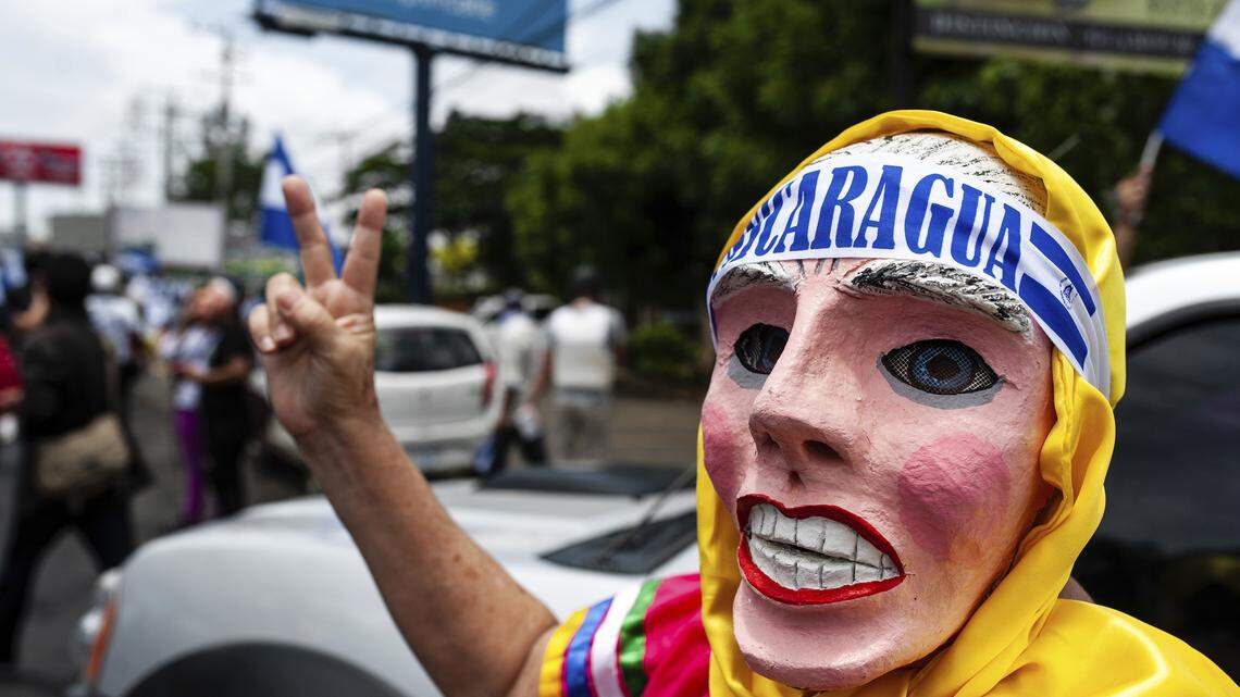 A masked anti-government demonstrator wearing a folkloric mask strikes a pose during a march demanding the ouster of President Daniel Ortega and the release of political prisoners, in Managua, Nicaragua, Saturday, July 21, 2018. (AP Photo/Cristobal Venegas)