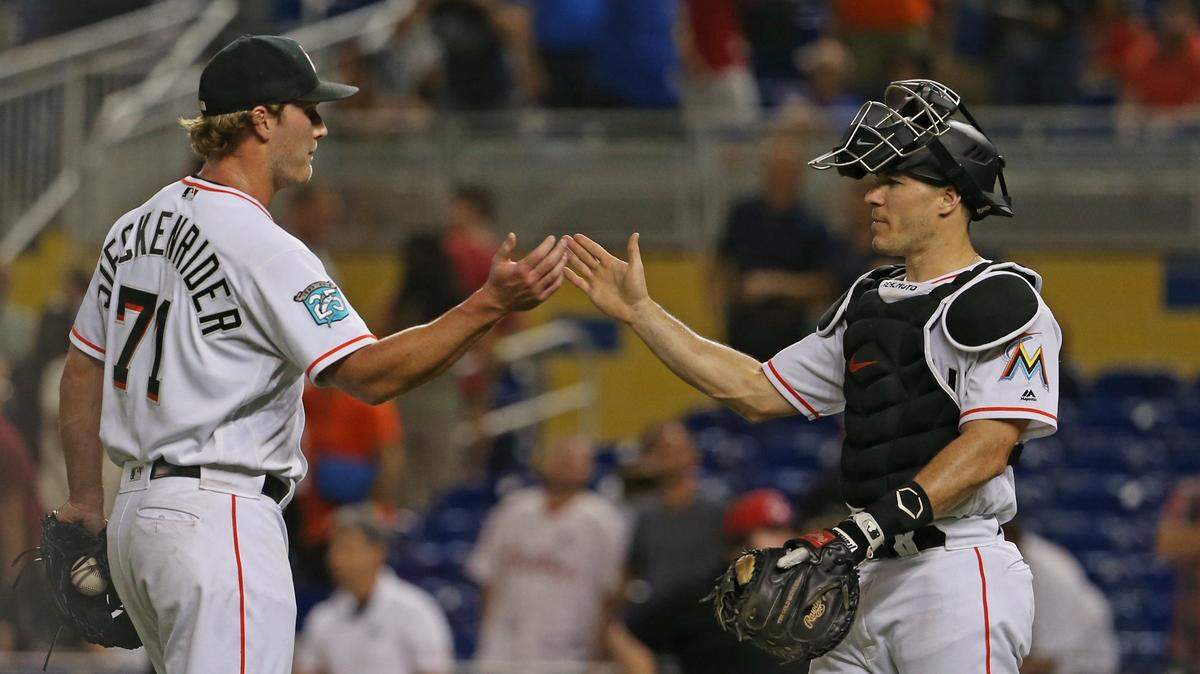 El relevista de los Marlins Drew Steckenrider (izq.) celebra con el catcher J.T. Realmuto tras la victoria en el partido ante los Filis, el 5 de septiembre de 2018 en Miami.