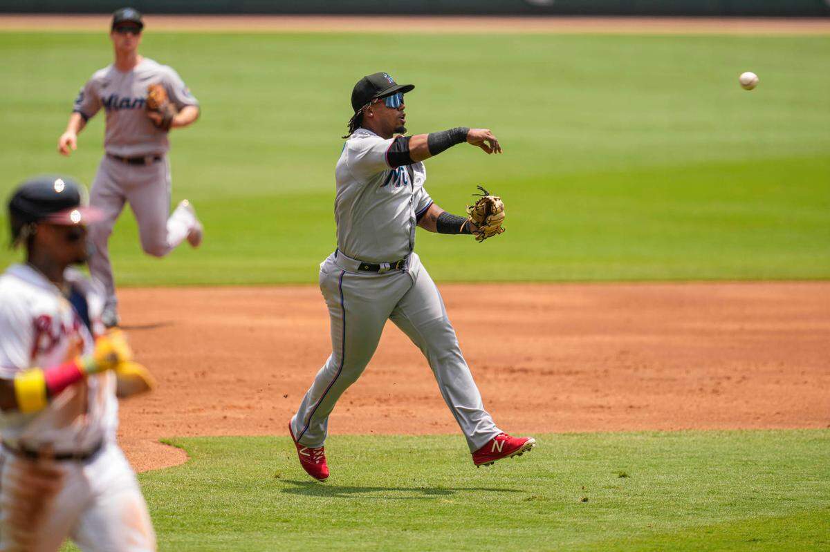 El tercera base de los Marlins Jean Segura tira a primera base para poner out al bateador designado de los Bravos Marcell Ozuna, en el primer inning del partido celebrado el 2 de julio de 2023 en Atlanta.
