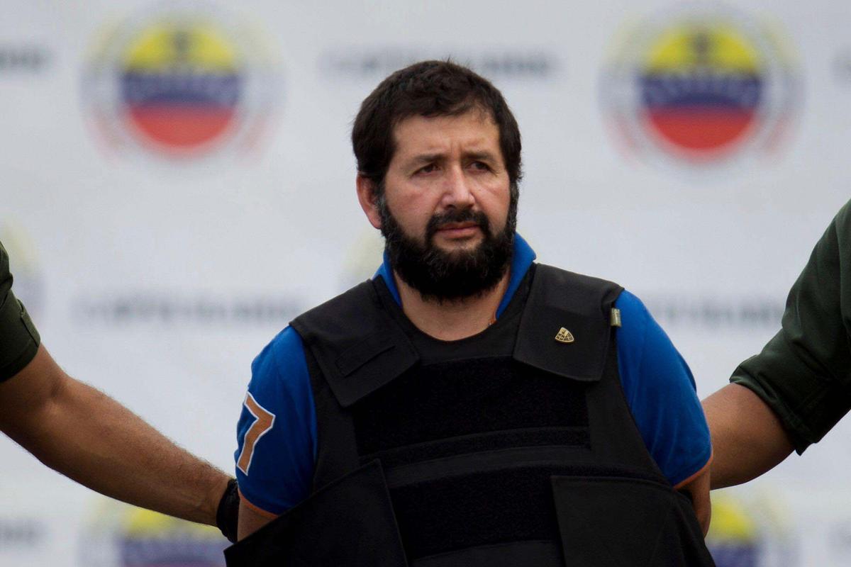 Daniel El Loco Barrera, uno de los narcotraficantes más buscados de Colombia, es escoltado por agentes de policía en el aeropuerto Simón Bolívar de Caracas, Venezuela, el 14 de noviembre de 2012.