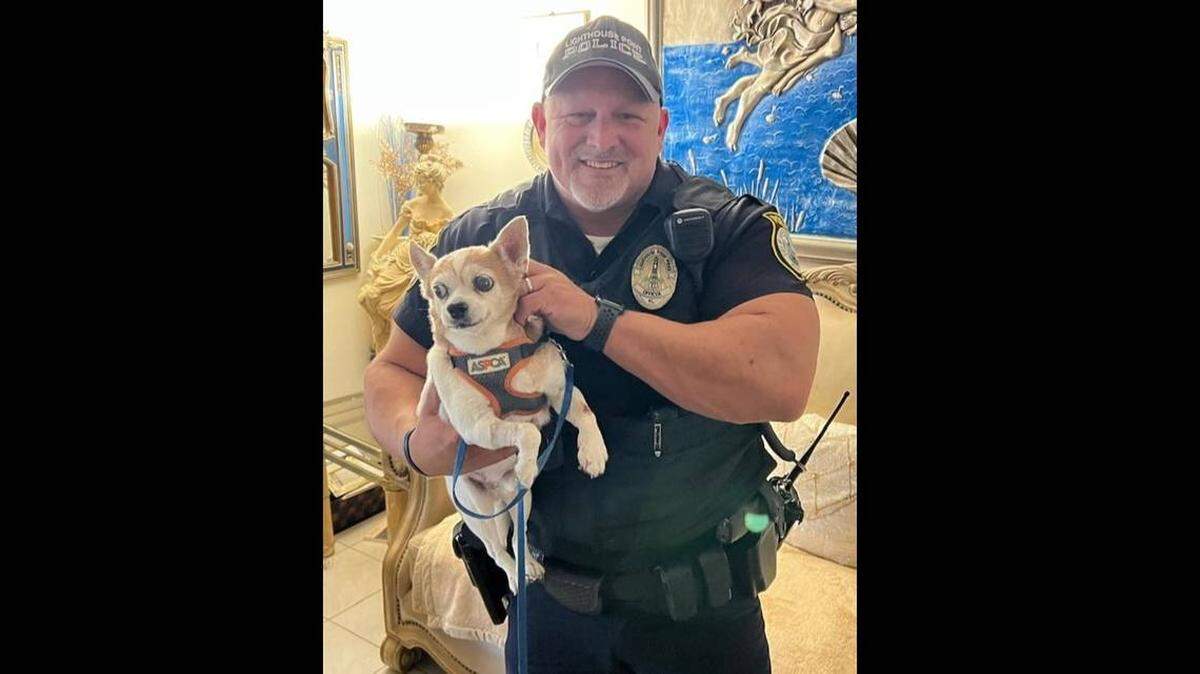 El agente Bob Stebbins, de la policía de Lighthouse Point, con el perro que rescató y evitó que se ahogara.