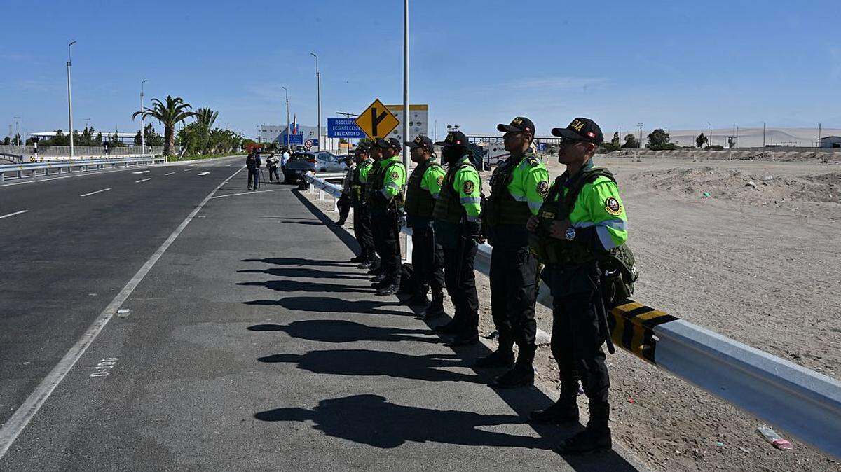 Peruvian police officers stand guard at the Cachalluta border crossing with Chile, about 25 km north of Arica, on November 30, 2025. Dozens of migrants seeking to leave Chile were stranded at the border with Peru, authorities said on Friday, amid fears sparked by far-right Chilean presidential candidate Jose Antonio Kast's threat to expel undocumented migrants. (Photo by RODRIGO ARANGUA / AFP via Getty Images)