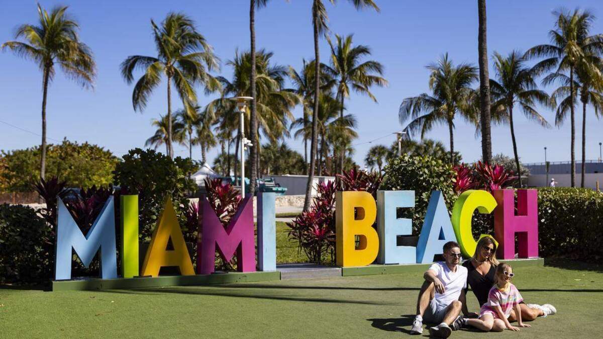 Personas se reúnen para una foto en Lummus Park, cerca de Ocean Drive, el martes 24 de febrero de 2026 en Miami Beach, Florida.