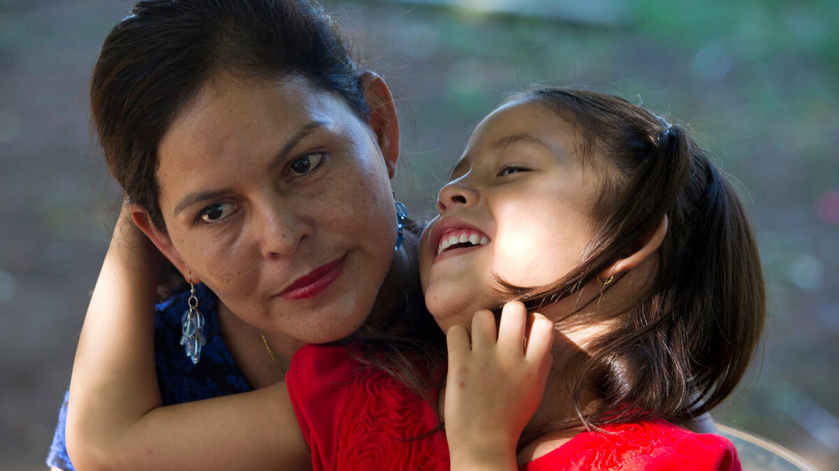 Araceli Ramos abraza a su hija de cinco años, Alexa, durante una entrevista en un parque de San Miguel, El Salvador. El sistema federal que tenía la custodia de Alexa alega que los tribunales estatales nunca debieron haber permitido que los padres de crianza llegaran tan lejos, sin importar lo buenas que fueses sus intenciones.