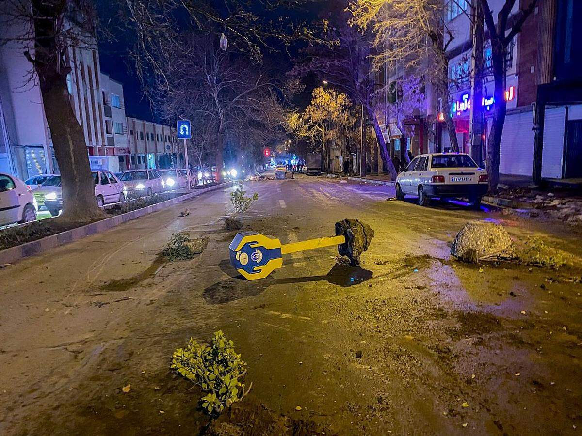 Piedras, ramas de árboles y una caja de donaciones derribada permanecen en una calle durante los disturbios en medio de las manifestaciones en Hamedan, Irán, el 1 de enero de 2026. Las manifestaciones estallaron después de que los comerciantes del Gran Bazar de Teherán cerraran sus negocios para protestar por la fuerte caída de la moneda iraní y el empeoramiento de la situación económica. Se registraron enfrentamientos en varias provincias, y medios de comunicación iraníes y grupos de derechos humanos informaron de la muerte de varias personas a causa de la violencia, lo que supuso las mayores protestas que ha vivido la República Islámica en tres años.