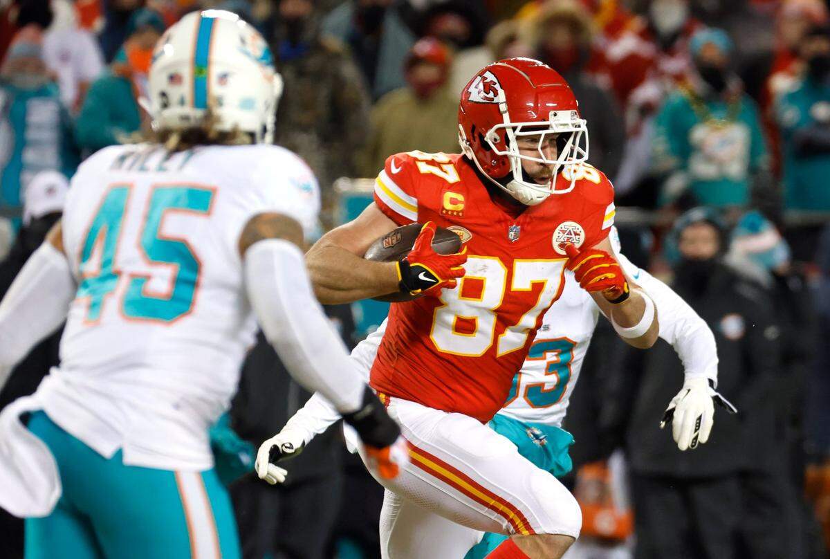 El tight end de los Chiefs Travis Kelce (87) corre con el ovoide en el partido de playoffs contra los Dolphins de Miami, celebrado el 13 de enero de 2024 en el Arrowhead Stadium en Kansas City, Missouri.