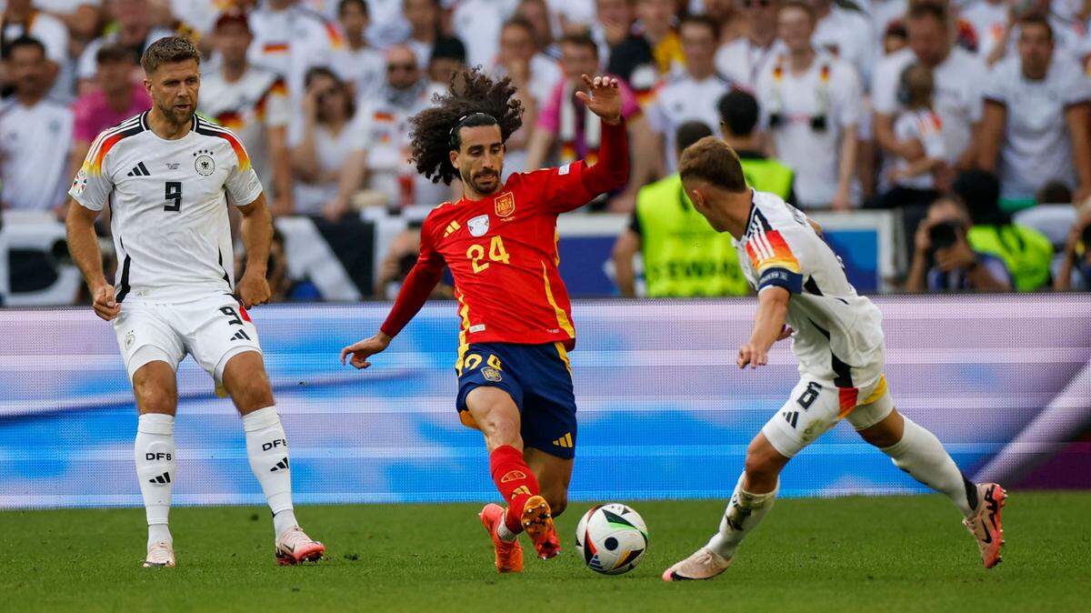 El español Marc Cucurella (centro) en acción ante los alemanes Niclas Fuellkrug (izq.) y Joshua Kimmich, durante el partido de cuartos de final de la Eurocopa celebrado en Stuttgart, Alemania, el 5 de julio de 2024.  