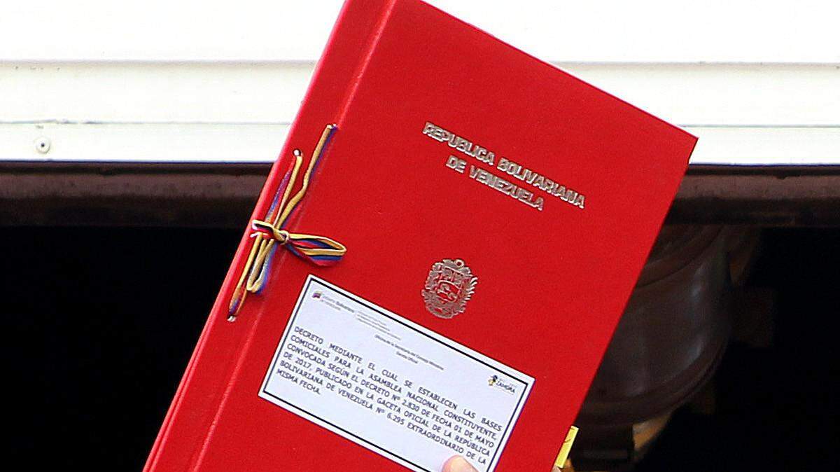 El presidente de Venezuela, Nicolás Maduro (c), muestra el decreto con la propuesta de Constituyente durante un acto oficial el martes 23 de mayo de 2017, en Caracas 