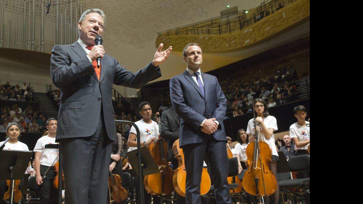 El presidente colombiano, Juan Manuel Santos (L), gesticula al pronunciar un discurso junto al presidente francés Emmanuel Macron (R), antes de un concierto en la sala de conciertos de la Filarmonía de París en París (Francia), el 23 de junio de 2017.