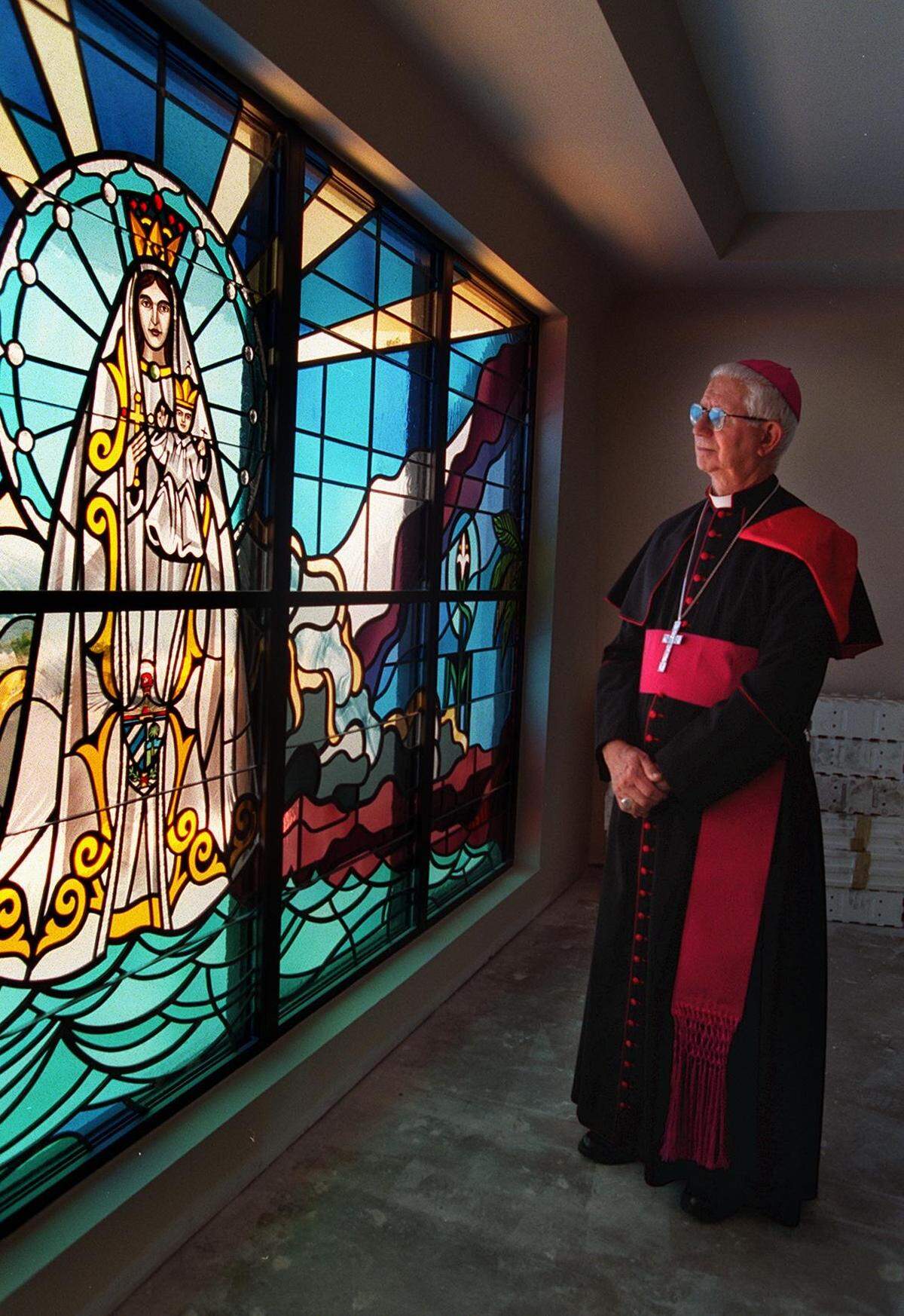 Monseñor Agustín Román contempla un vitral de la Virgen de la Caridad, Patrona de Cuba, en abril de 1998.