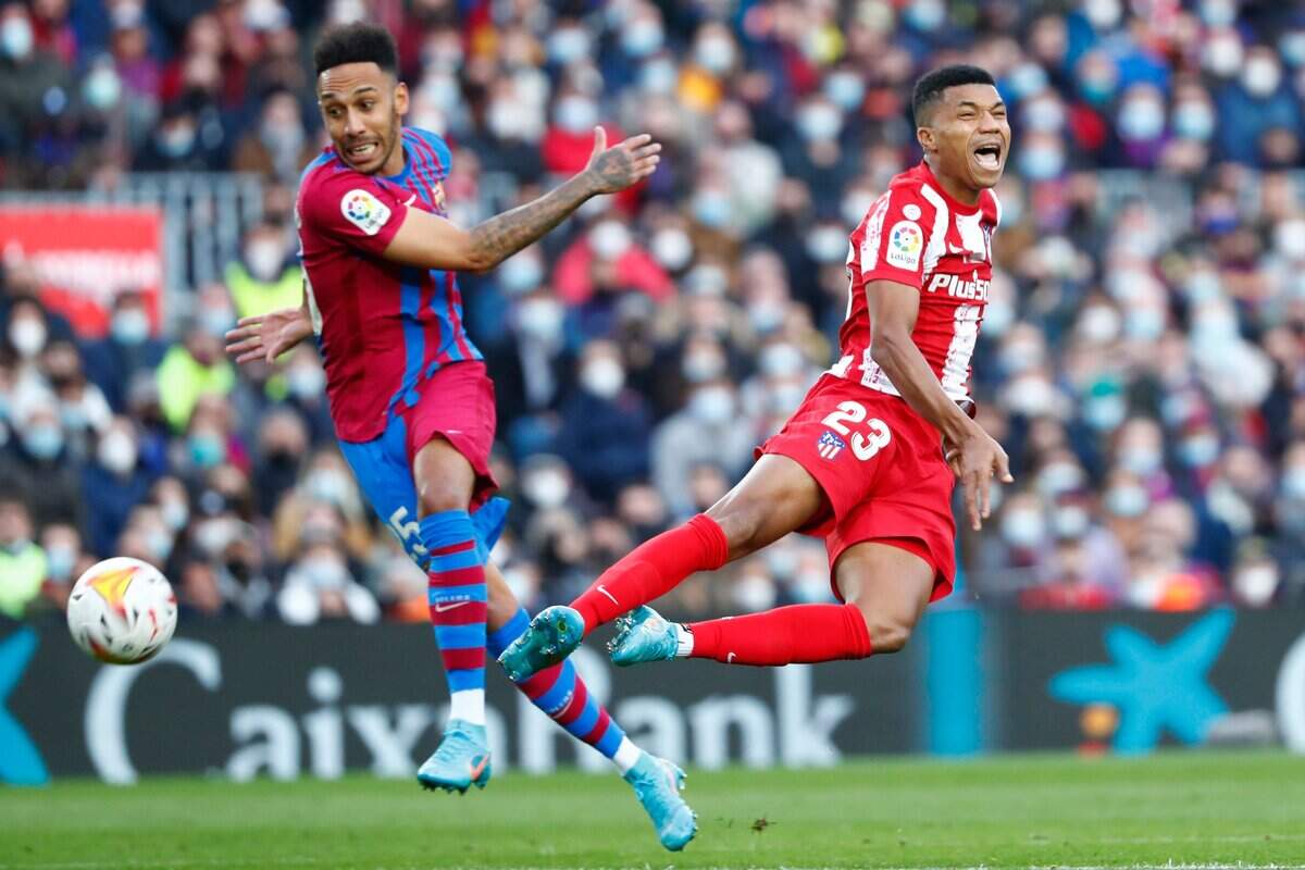 El jugador de Barcelona Pierre-Emerick Aubameyang (izq.) lucha por la pelota con Reinildo Mandava, del Atlético de Madrid, en el partido celebrado el 6 de febrero de 2022 en Barcelona.