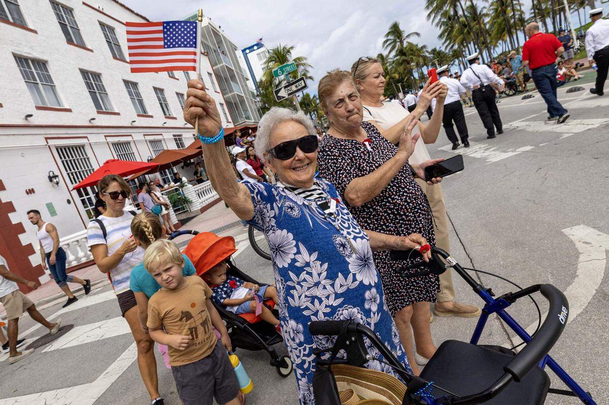 Josefina González ondea una bandera durante el desfile del Día de los Veteranos de 2024 en Miami Beach.