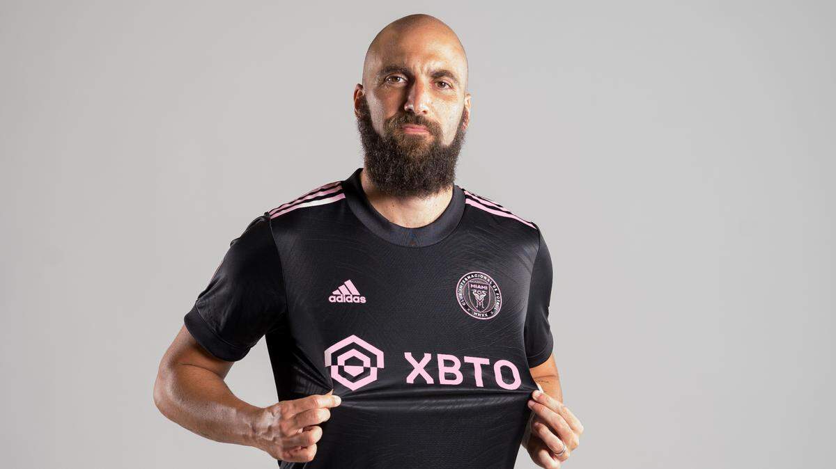 El delantero del Inter Miami Gonzalo Higuaín modela la nueva camiseta con el patrocinador XBTO en el frente.