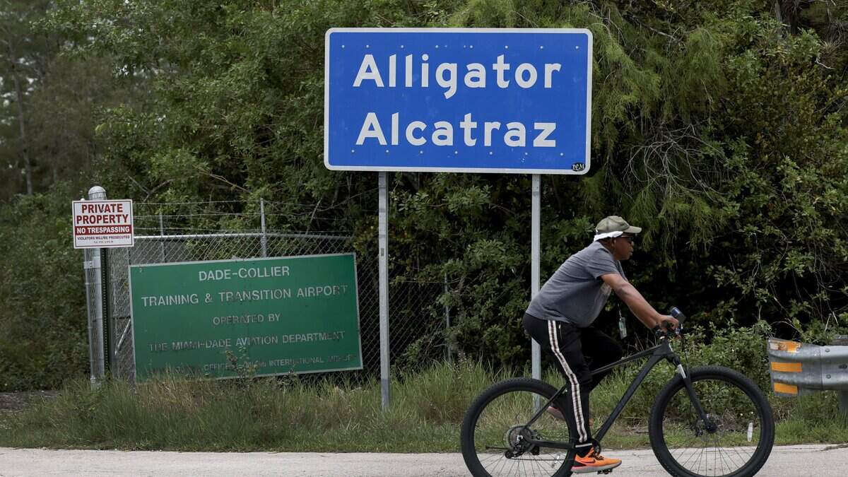 Un ciclista pasa frente al letrero de la entrada principal del centro de detención para inmigrantes en los Everglades de Florida, conocido como “Alligator Alcatraz”, el 1 de junio de 2026 en Ochopee, Florida. Informes indican que la instalación será cerrada, posiblemente tan pronto como este mismo mes.