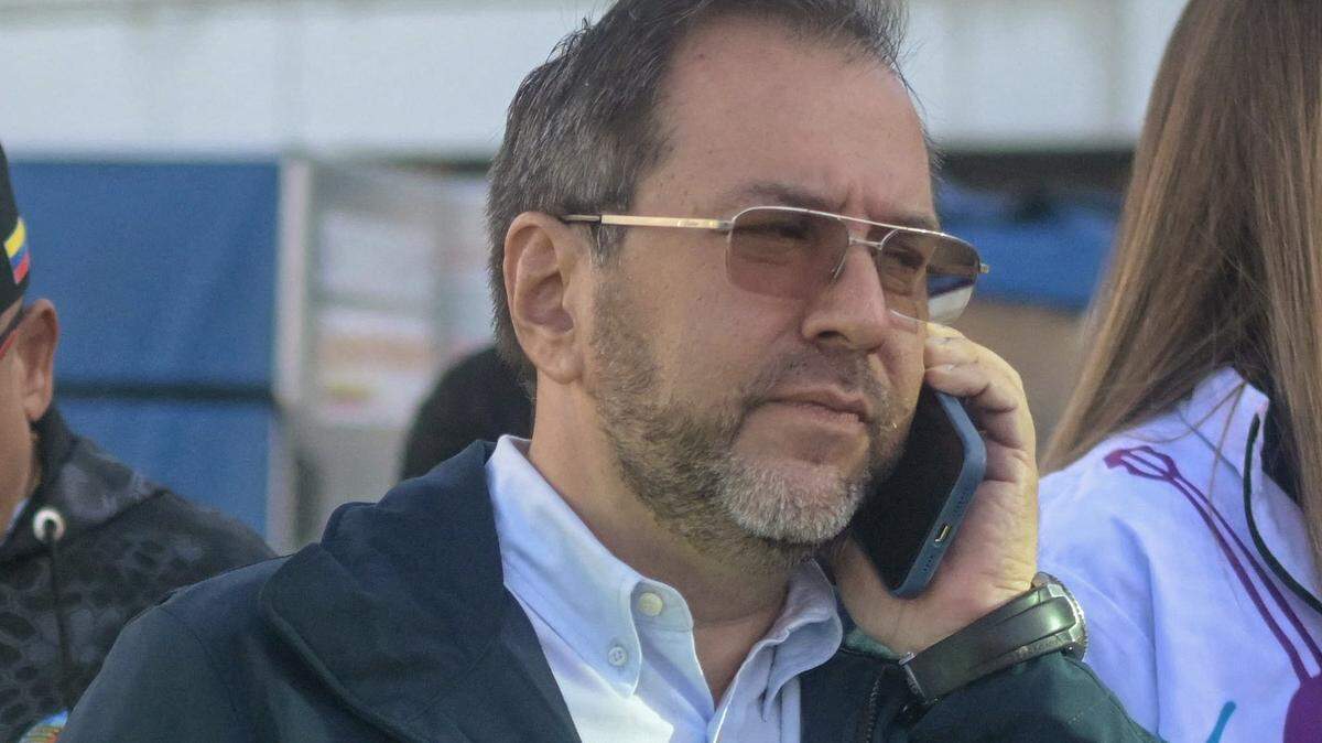 El ministro de Relaciones Exteriores de Venezuela, Yván Gil, usa su teléfono mientras espera un avión de Eastern Airlines que transporta migrantes venezolanos repatriados desde Estados Unidos en el Aeropuerto Internacional Simón Bolívar, en Maiquetía, Venezuela, el 3 de diciembre de 2025.