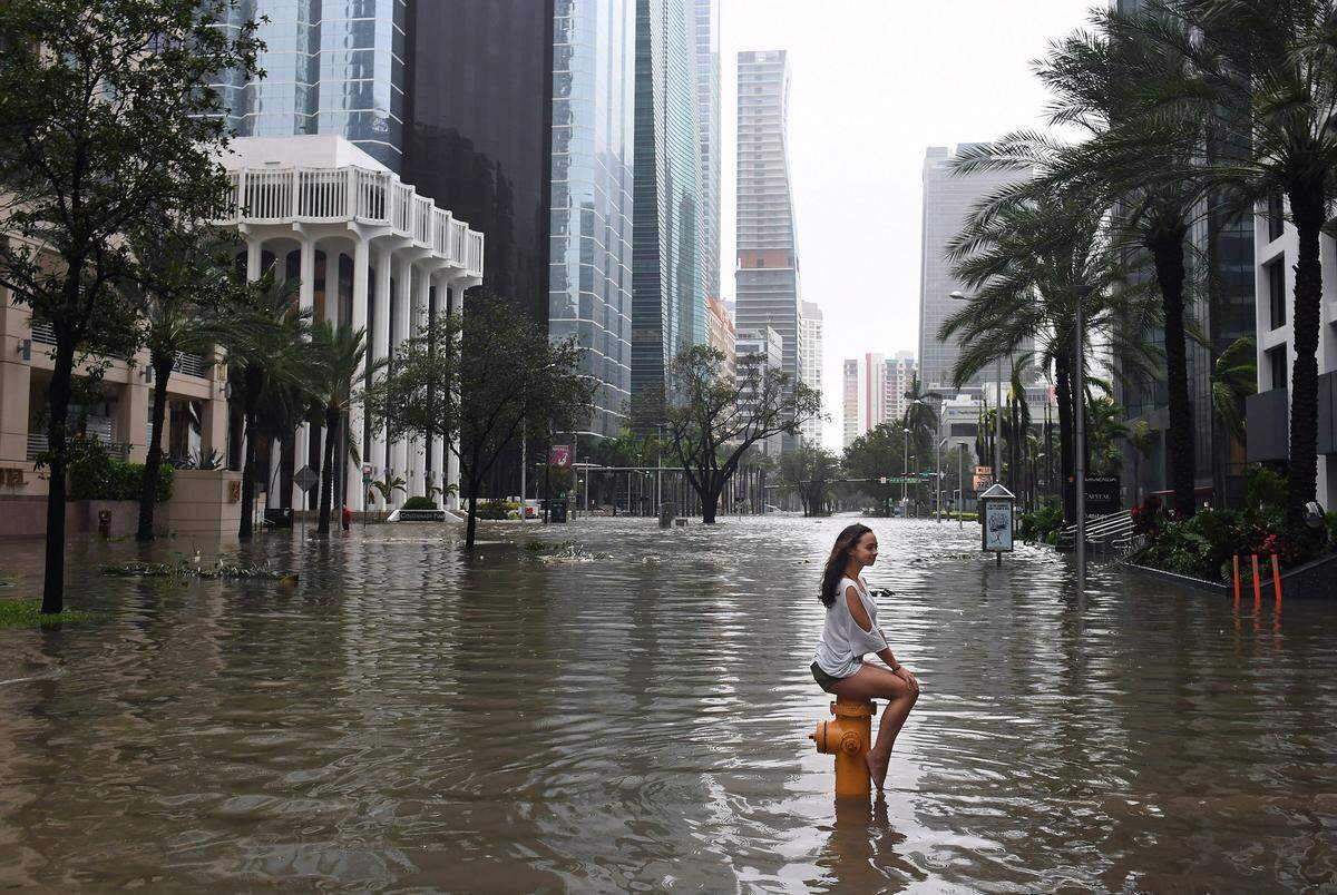 Mia Herman sits on a fire hydrant in Brickell following Hurricane Irma, which badly flooded much of the coastal neighborhood’s pricey real estate.
