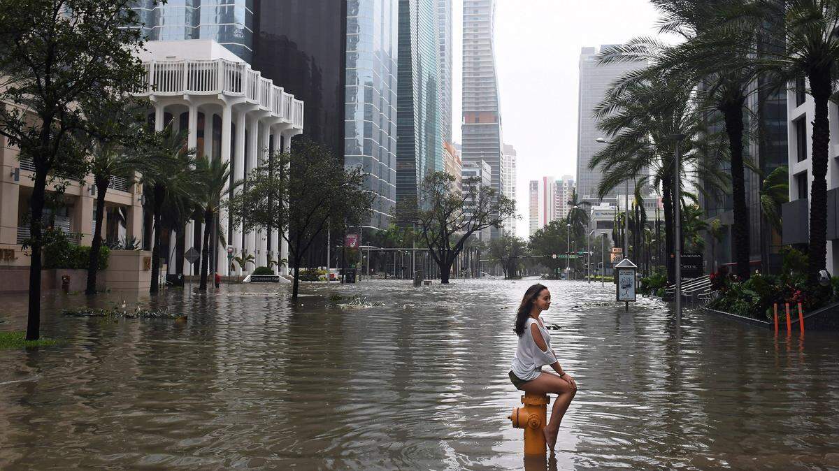 Mia Herman sits on a fire hydrant in Brickell following Hurricane Irma, which badly flooded much of the coastal neighborhood’s pricey real estate. Without wetlands, which soak up a lot of excess water, flooding would have been much worse.